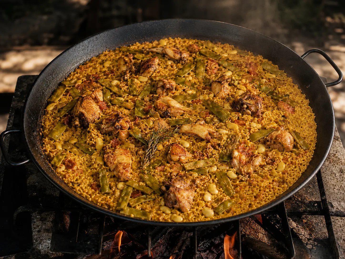 Paella Valenciana met rijst, kip, konijn, ferradura en garrofó boven houtvuur